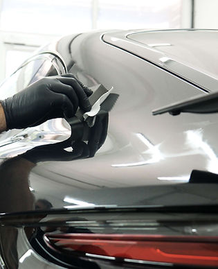 A detailer applying ceramic coating to a black vehicle
