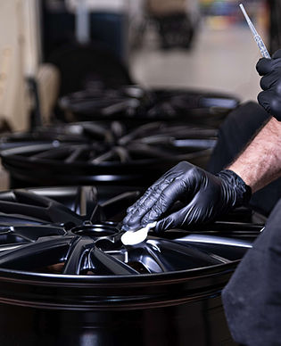 Ceramic coating being applied to a black alloy wheel